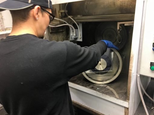 Operator removing silvered disk from VLSS unit at production site